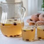 Finnish sima lemon drink in a pitcher and glasses with raisins.