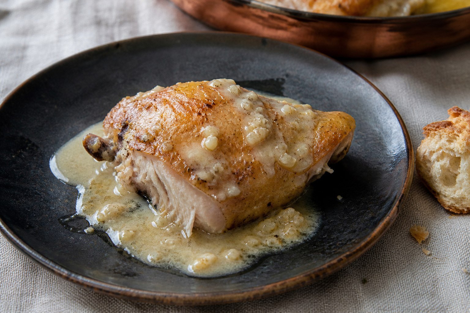 A serving of Georgian garlic chicken with sauce and bread.