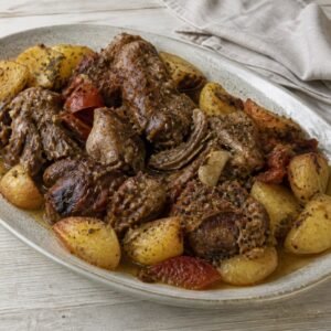 Slow-cooked Greek lamb kleftiko with lemon potatoes and herbs.