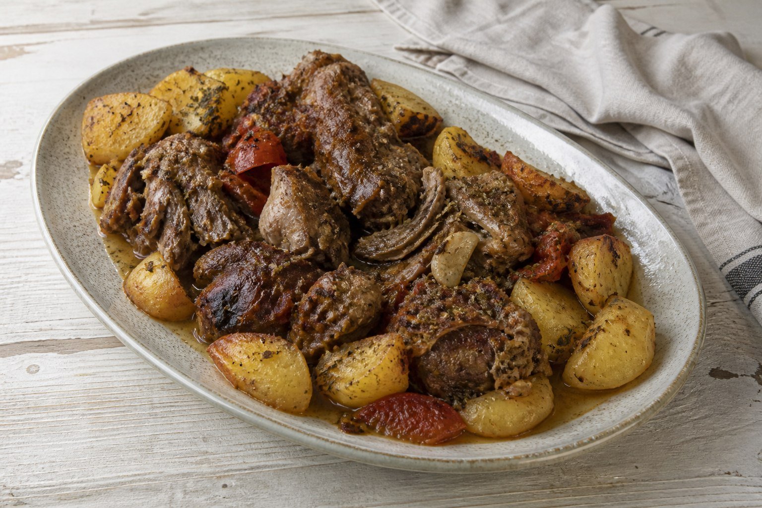 Slow-cooked Greek lamb kleftiko with lemon potatoes and herbs.