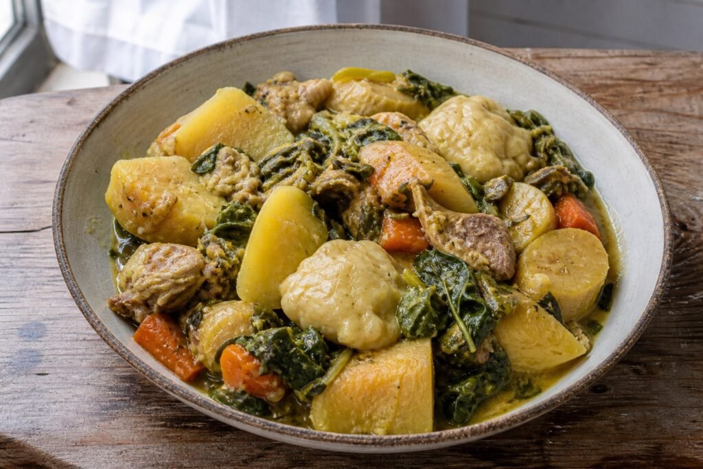Grenadian oil down with breadfruit, callaloo, salted meat, green banana, dumplings, and coconut milk.