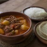 Guatemalan hilachas with shredded beef and potatoes beside rice and tortillas.