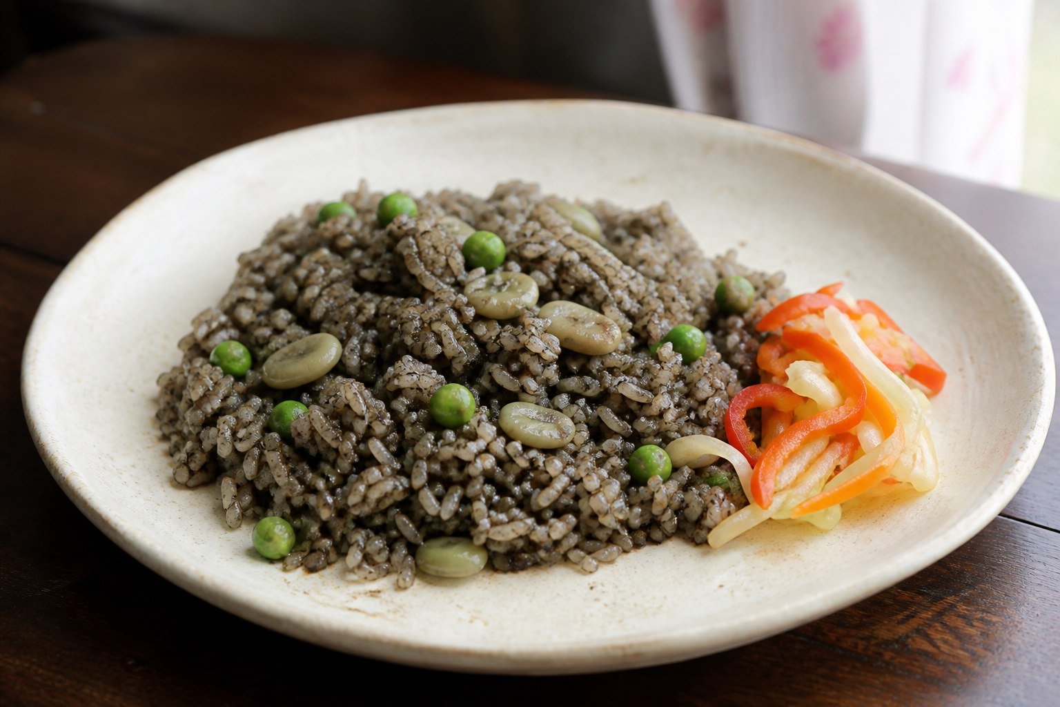 Haitian diri ak djon djon mushroom rice with peas, lima beans, and a small serving of pikliz.