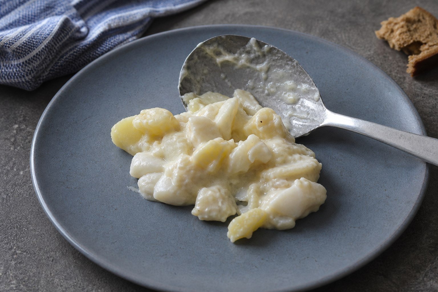 A serving spoon beside Icelandic plokkfiskur on a blue-gray plate.