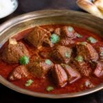 Indian rogan josh with tender lamb in a deep red aromatic gravy.