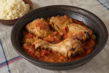 Ivorian kedjenou chicken stew with tomato, peppers, onions, and attieke.