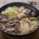 Japanese sukiyaki with thin beef, tofu, napa cabbage, mushrooms, scallions, and shirataki.