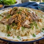 Jordanian mansaf with tender lamb, rice, jameed sauce, almonds, and parsley.
