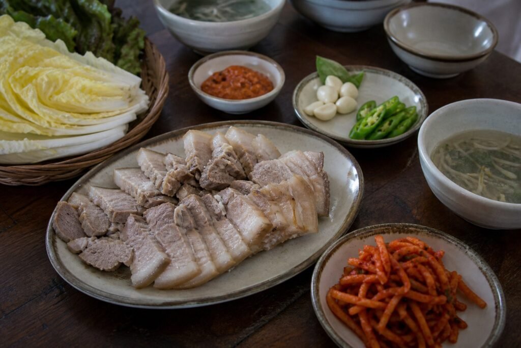 Korean bossam pork belly with napa cabbage, radish salad, garlic, chile, and ssamjang.