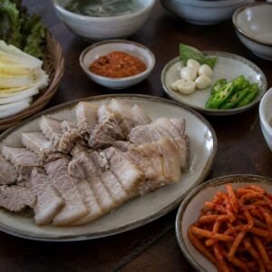 Korean bossam pork belly with napa cabbage, radish salad, garlic, chile, and ssamjang.