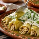 Mexican chicken enchiladas verdes covered in tomatillo sauce, crema, queso fresco, and cilantro.