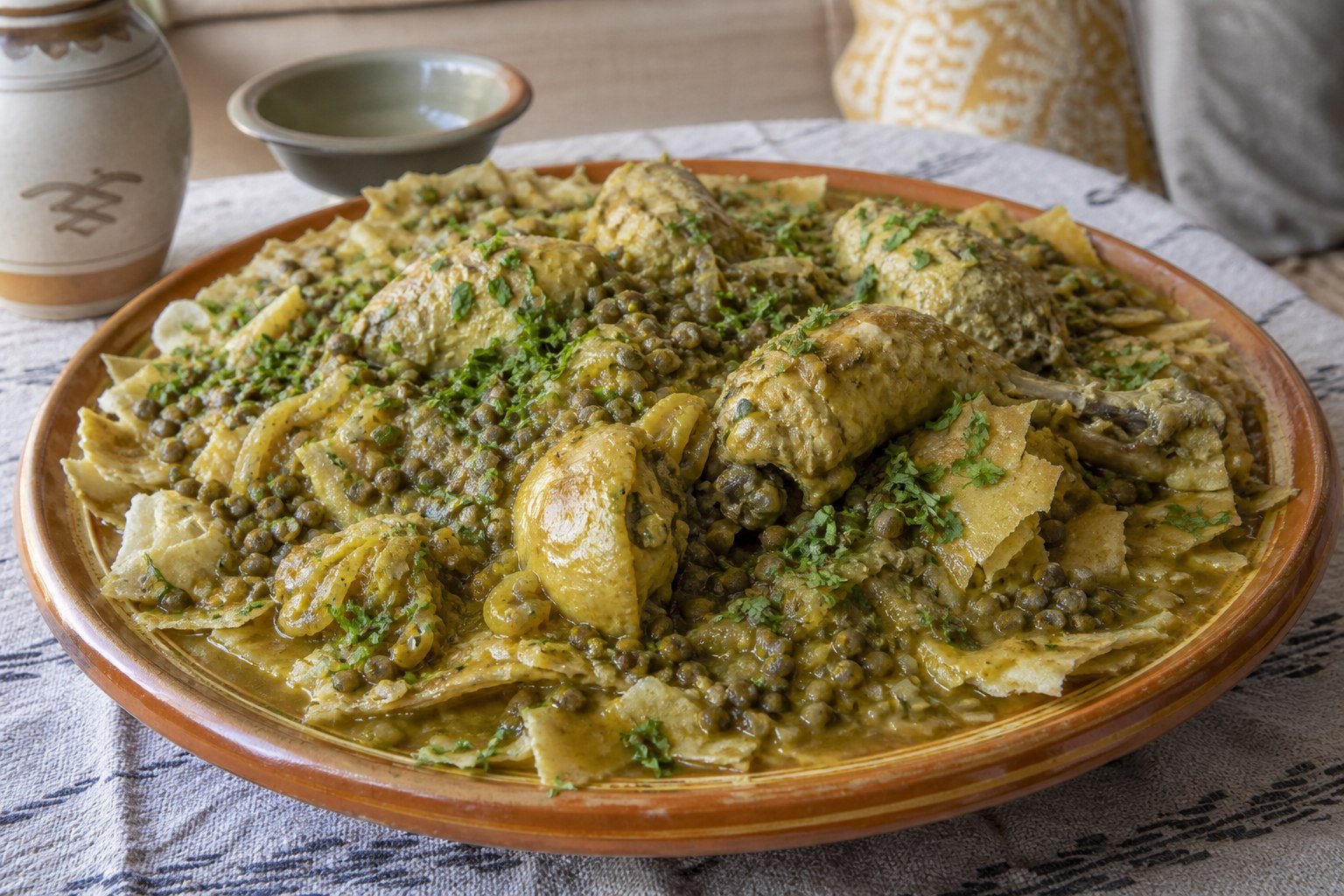 Moroccan rfissa with chicken, lentils, onions, and torn layered flatbread.