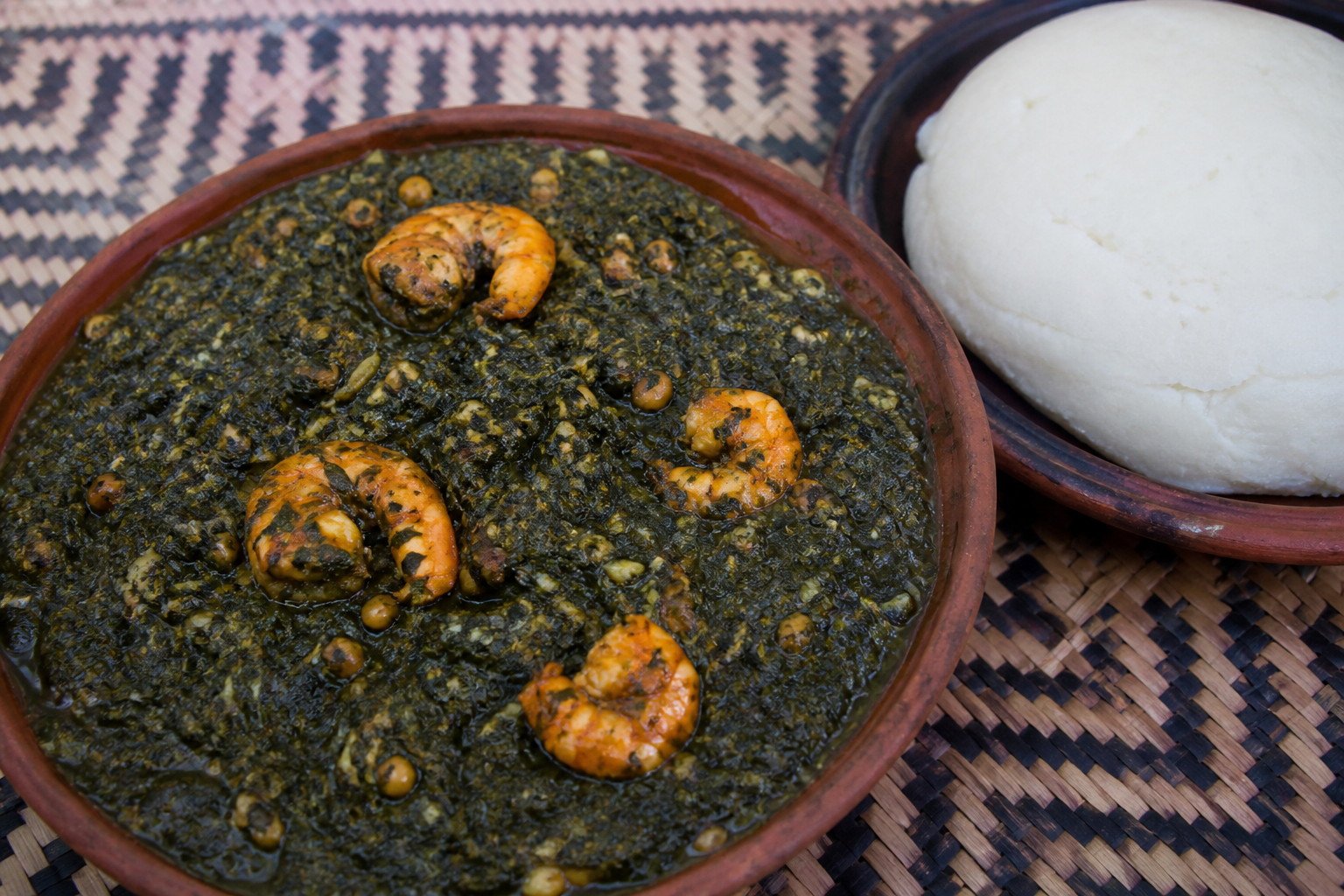 Mozambican matapa with shrimp served beside white xima.