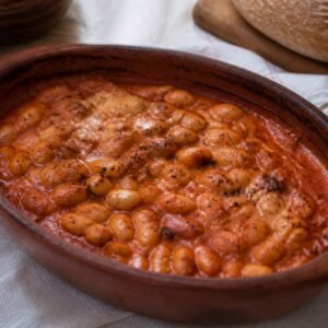 North Macedonian tavce gravce baked beans in a traditional earthenware dish.