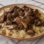 Omani shuwa served over spiced long-grain rice.