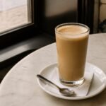 Portuguese galão coffee with hot milk in a tall café glass.