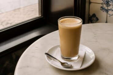 Portuguese galão coffee with hot milk in a tall café glass.