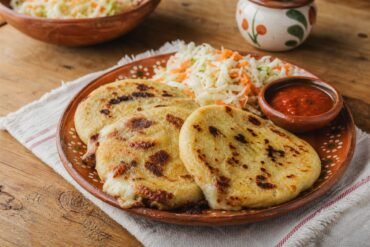 Golden Salvadoran pupusas served with curtido and tomato salsa.