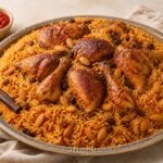 Roasted chicken kabsa served over spiced basmati rice with almonds and raisins.