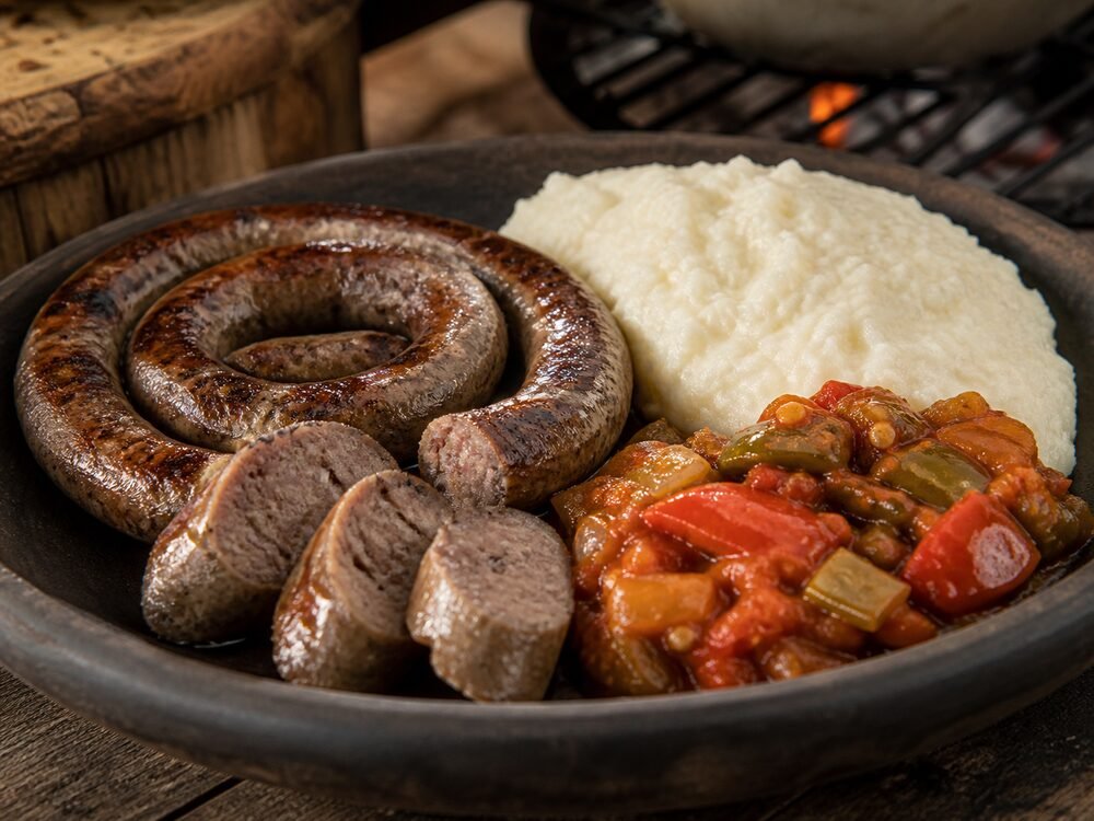 Sliced grilled boerewors served with creamy pap and tomato-pepper chakalaka.