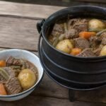 South African beef potjiekos served from a black cast-iron potjie.