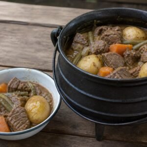 South African beef potjiekos served from a black cast-iron potjie.