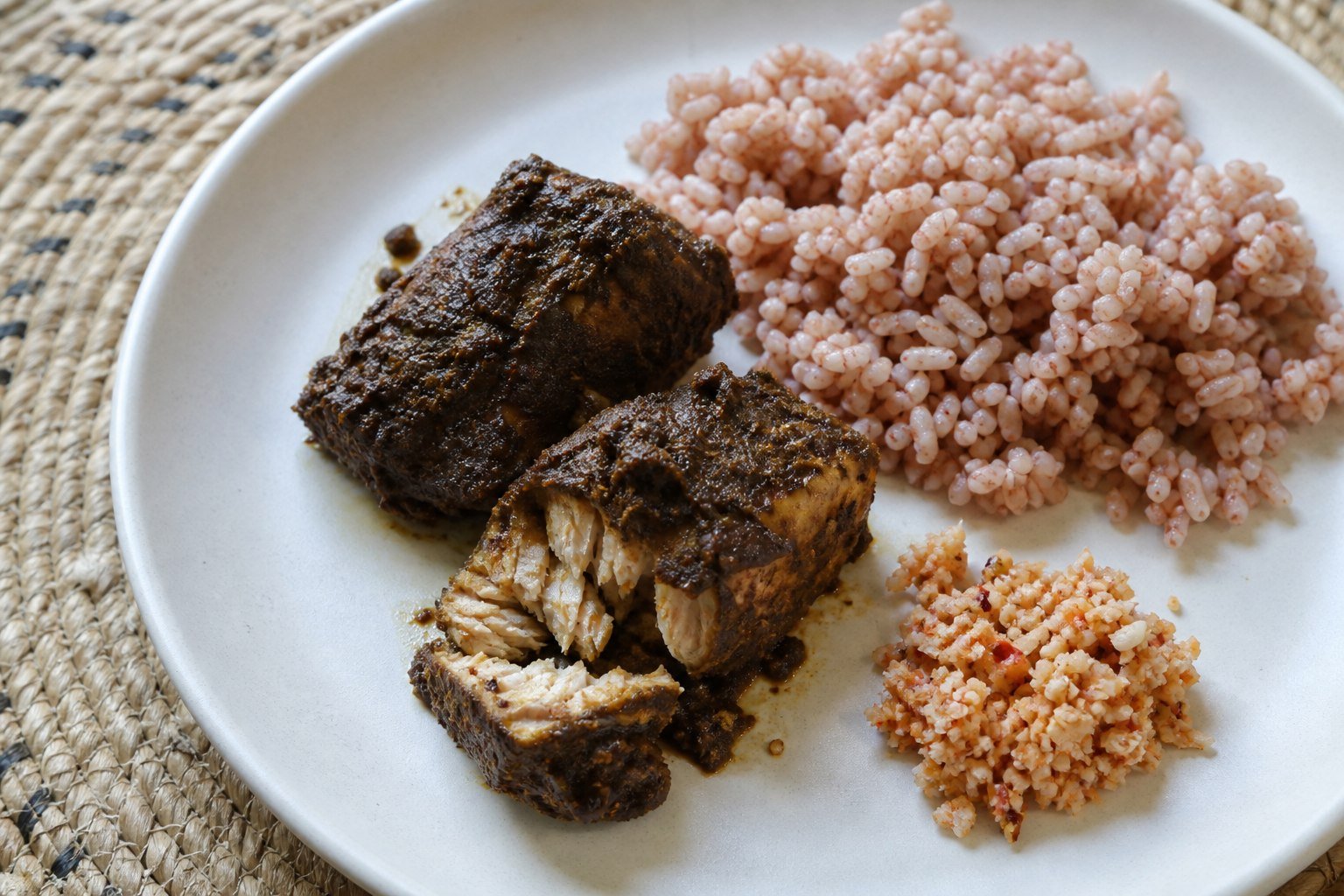 Sri Lankan fish ambul thiyal served with red rice and coconut sambol.