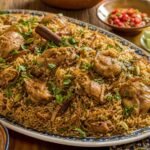 A platter of Tanzanian pilau with spiced rice, chicken, and caramelized onions.