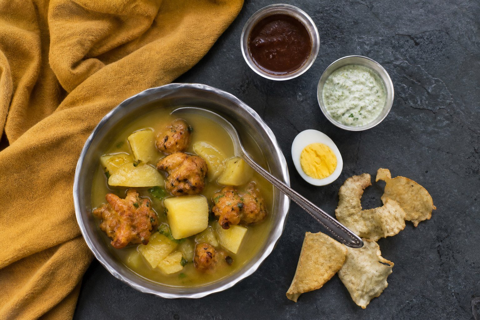 An overhead serving of Zanzibar mix with chutneys, egg, and cassava crisps.