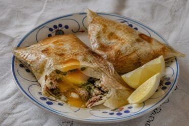 Tunisian brik pastries filled with soft egg, tuna, herbs, and capers.
