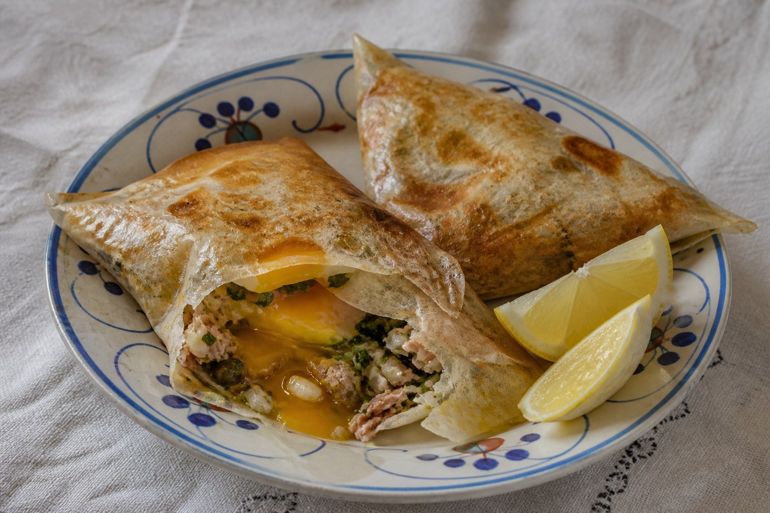 Tunisian brik pastries filled with soft egg, tuna, herbs, and capers.