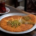 Golden Turkish kunefe with melted cheese and crushed pistachios.