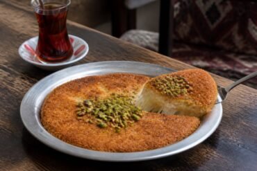 Golden Turkish kunefe with melted cheese and crushed pistachios.