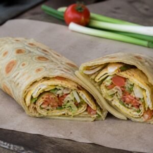 Ugandan rolex chapati wraps cut open to show vegetable omelet filling.