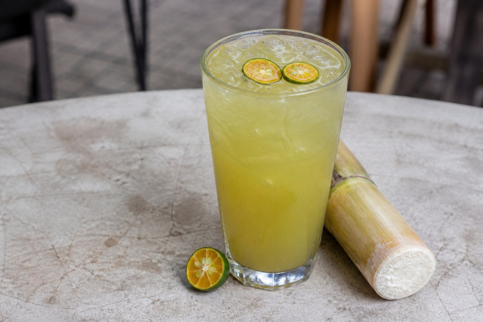 Vietnamese fresh sugarcane juice with kumquat and ice in a tall glass.