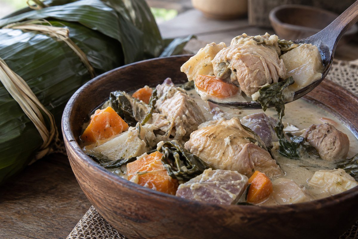 A spoon serving chicken and root vegetables from New Caledonian bougna.