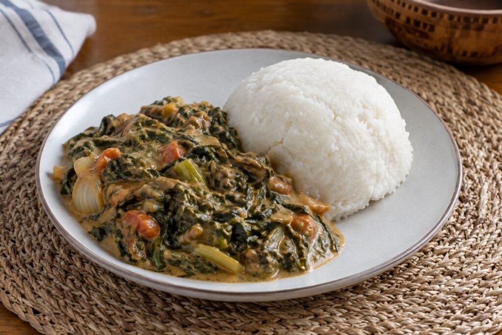 Zambian Ifisashi leafy greens in peanut sauce served with a mound of nshima.